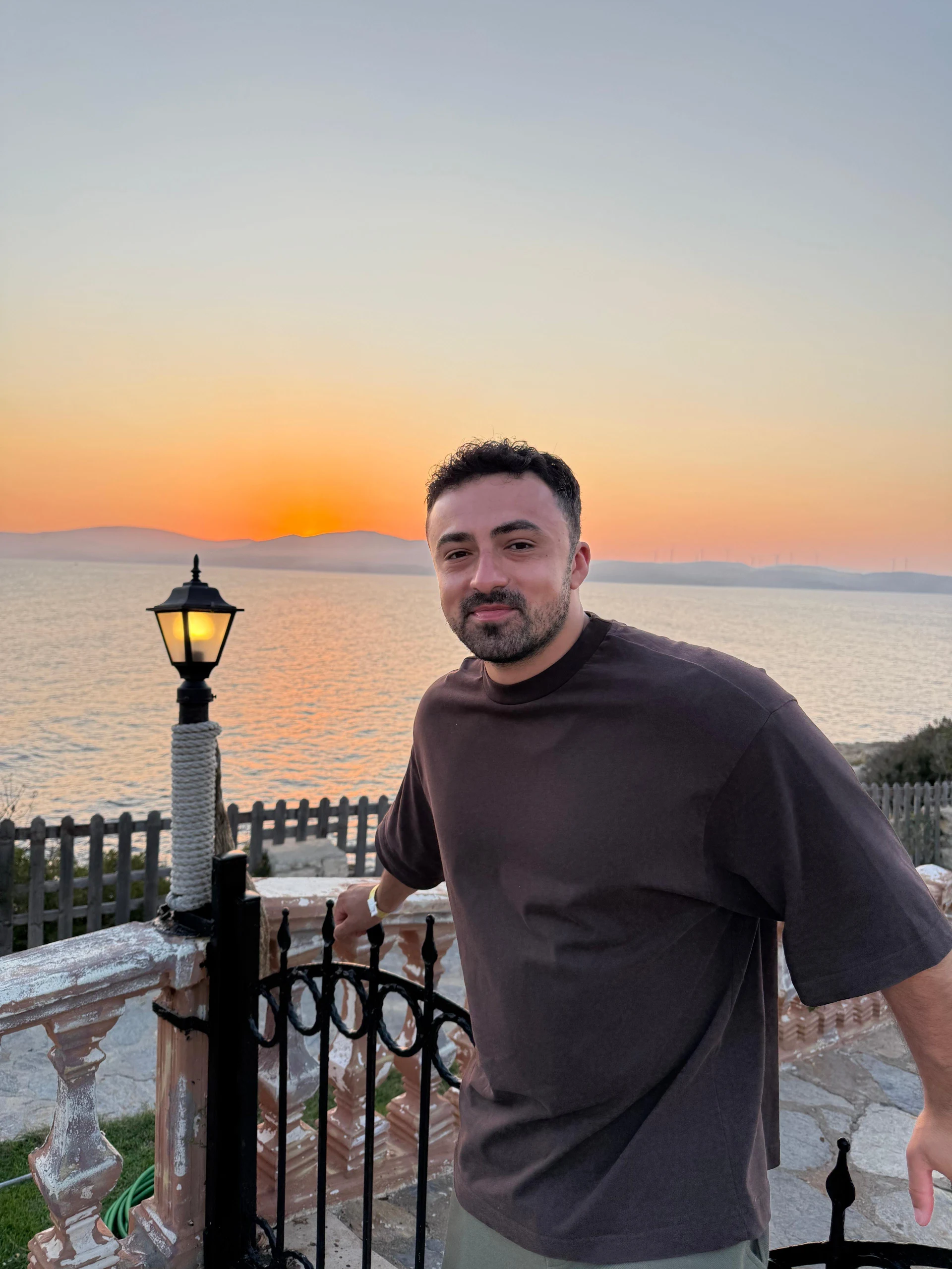 Yağız Cem Yılmaz, gün batımında deniz kıyısında